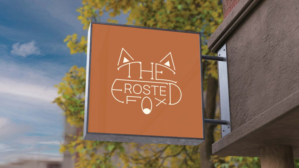 An outdoor sign for The Frosted Fox Cake Shop